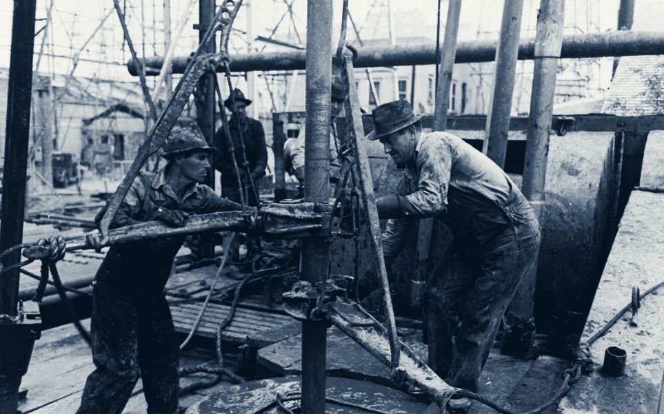 Roughnecks making a connection on the drill floor - archival photograph. The trade has a lineage; we train the next generation of it